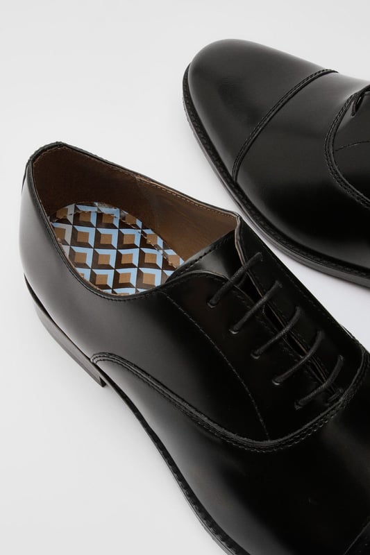 Classic Oxford design with traditional toe cap detailing
        High shine genuine leather upper for a sophisticated finish
        Traditional lace-up fastening with five eyelets for secure fit
        Sleek silhouette with minimal stitching for a clean, refined look
        Versatile design suitable for both formal occasions and smart-casual settings
    
    These timeless Oxford shoes from Burton combine classic British styling with everyday versatility. The high shine leather construction creates a polished appearance that works effortlessly with formal attire, while remaining understated enough for more relaxed occasions. Pair with tailored trousers as shown for business meetings or important events, or style with dark denim for smart pub lunches with mates. The traditional toe cap and clean lines reflect a heritage-inspired aesthetic that never goes out of fashion. Comfortable enough for all-day wear at the office, yet smart enough for special occasions, these Oxfords represent the perfect balance of practicality and style. Their durable construction ensures they'll remain a wardrobe staple for years to come - simply buff regularly to maintain their distinguished shine.