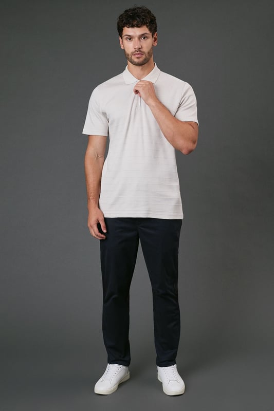 Textured stripe pattern adds subtle visual interest to this classic polo design
        Quarter-zip neck detail offers versatile styling options and a contemporary twist
        Comfortable cotton fabric ensures breathability for all-day wear
        Neat collar with ribbed finish maintains its shape throughout the day
        Relaxed short sleeves provide ease of movement for casual activities
    
    This Burton textured stripe polo combines timeless appeal with modern detailing, perfect for the man who appreciates classic style with a contemporary edge. The quarter-zip neck allows you to customise your look throughout the day, whether partially unzipped for a relaxed pub lunch or fully zipped for a smarter finish. Pair with dark trousers as shown for an effortlessly smart-casual ensemble that works brilliantly for family gatherings or weekend outings. The textured stripe pattern adds subtle sophistication while maintaining versatility. For summer barbecues or casual sporting events, team with chino shorts and trainers, or layer under a lightweight jacket when the temperature drops. Machine washable and easy to maintain, this polo represents the perfect balance of comfort and style for your everyday wardrobe.