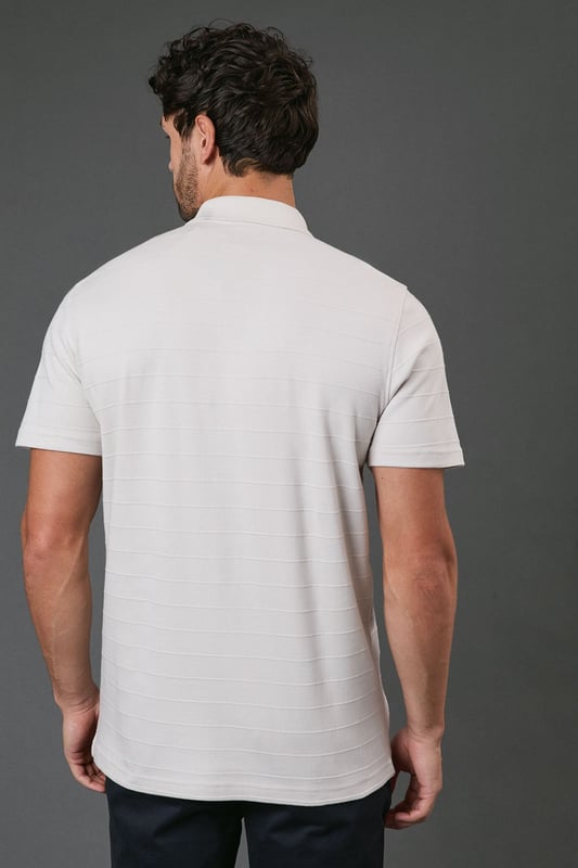 Textured stripe pattern adds subtle visual interest to this classic polo design
        Quarter-zip neck detail offers versatile styling options and a contemporary twist
        Comfortable cotton fabric ensures breathability for all-day wear
        Neat collar with ribbed finish maintains its shape throughout the day
        Relaxed short sleeves provide ease of movement for casual activities
    
    This Burton textured stripe polo combines timeless appeal with modern detailing, perfect for the man who appreciates classic style with a contemporary edge. The quarter-zip neck allows you to customise your look throughout the day, whether partially unzipped for a relaxed pub lunch or fully zipped for a smarter finish. Pair with dark trousers as shown for an effortlessly smart-casual ensemble that works brilliantly for family gatherings or weekend outings. The textured stripe pattern adds subtle sophistication while maintaining versatility. For summer barbecues or casual sporting events, team with chino shorts and trainers, or layer under a lightweight jacket when the temperature drops. Machine washable and easy to maintain, this polo represents the perfect balance of comfort and style for your everyday wardrobe.