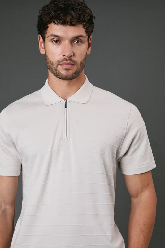 Textured stripe pattern adds subtle visual interest to this classic polo design
        Quarter-zip neck detail offers versatile styling options and a contemporary twist
        Comfortable cotton fabric ensures breathability for all-day wear
        Neat collar with ribbed finish maintains its shape throughout the day
        Relaxed short sleeves provide ease of movement for casual activities
    
    This Burton textured stripe polo combines timeless appeal with modern detailing, perfect for the man who appreciates classic style with a contemporary edge. The quarter-zip neck allows you to customise your look throughout the day, whether partially unzipped for a relaxed pub lunch or fully zipped for a smarter finish. Pair with dark trousers as shown for an effortlessly smart-casual ensemble that works brilliantly for family gatherings or weekend outings. The textured stripe pattern adds subtle sophistication while maintaining versatility. For summer barbecues or casual sporting events, team with chino shorts and trainers, or layer under a lightweight jacket when the temperature drops. Machine washable and easy to maintain, this polo represents the perfect balance of comfort and style for your everyday wardrobe.