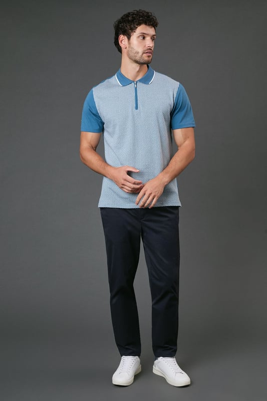 Distinctive jacquard pattern across the front body for a textured appearance
        Quarter-zip neckline with contrast tipping for a sporty finish
        Contrast solid sleeves creating a modern colour-block effect
        Ribbed collar with contrast trim for a refined touch
        Comfortable cotton fabric ideal for all-day wear
    
    This Burton jacquard polo offers a contemporary twist on a classic style. The textured pattern across the front creates visual interest whilst maintaining a sophisticated look that works perfectly for various casual occasions. Style it as shown with dark trousers and white trainers for an effortlessly smart weekend outfit, or pair with your favourite jeans for a relaxed pub lunch with mates. The quarter-zip detail adds functionality and a sporty element that nods to active lifestyles without compromising on style. Perfect for summer barbecues, casual Fridays at the office, or watching the match with friends. The contrast sleeves and collar detailing provide just enough interest to stand out from standard polos in your wardrobe, whilst the cotton construction ensures breathability and comfort throughout the day. A versatile addition to any casual wardrobe that bridges the gap between laid-back and put-together.
