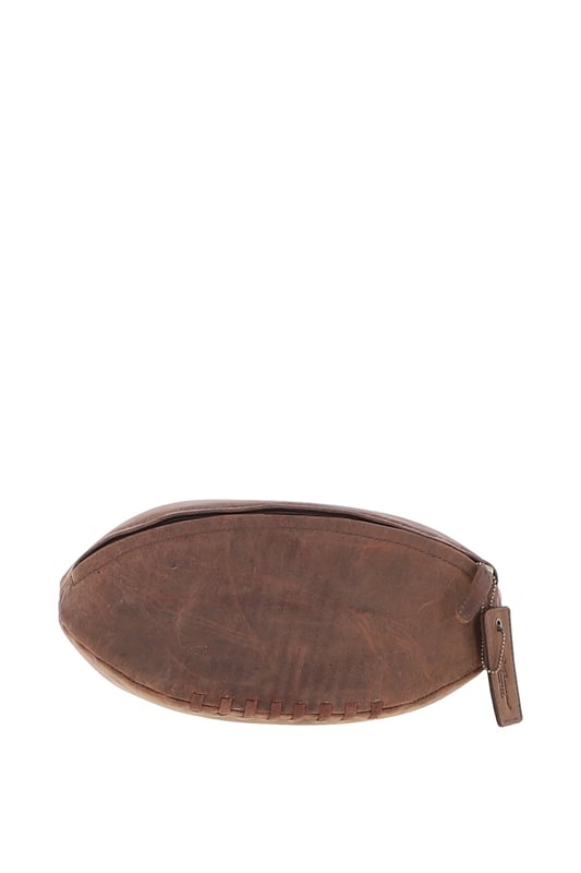 Add a touch of character to your travel kit with this unique rugby ball-shaped leather washbag. Crafted in smooth leather with hand-stitched detail and gold-coloured hardware, it combines eye-catching design with practical function. Despite its compact size, it offers a spacious main compartment with a secure zip closure—perfect for storing toiletries and grooming essentials. Ideal for stylish travellers or as a thoughtful gift for sports enthusiasts. Dimensions: (L) 29 cm x (W) 12 cm x (H) 12 cm.