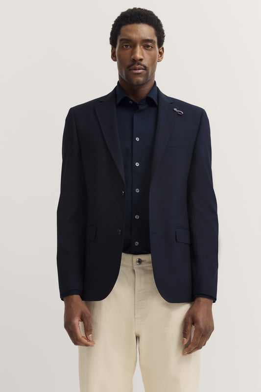 Das bugatti Sakko in hochwertiger Wollmischung vereint zeitlose Eleganz mit modernem Tragekomfort dank ´Modern Fit`. Der Reverskragen und die Brust- sowie Pattentaschen setzen stilvolle Akzente, während die Seitenschlitze für optimale Bewegungsfreiheit sorgen - perfekt für stilbewusste Herren, die Wert auf Qualität und Raffinesse legen.