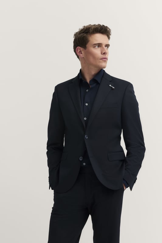 Mit dem bugatti Sakko erlebst Du ultimativen Komfort dank der integrierten Stretchfunktion und des hochwertigen Jersey-Stoffs. Der moderne Schnitt sorgt für eine zeitgemäße Silhouette, während Reverskragen, Pattentaschen und eine elegante Vollfütterung dem Sakko eine edle Note verleihen. Perfekt für den stilbewussten Mann.