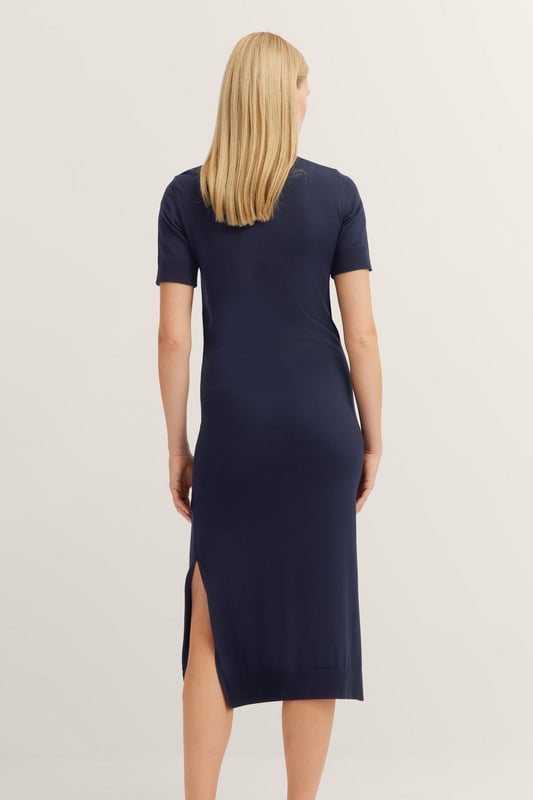 Mit dem Strickkleid von bugatti genießt Du maximalen Tragekomfort dank der elastischen Viskosequalität und dem klassischen Rundhalskragen. Die Seitenschlitze bieten optimale Bewegungsfreiheit, während die Bündchen an den Ärmeln für stilvollen Details sorgen - Dein idealer Begleiter für feminine Eleganz im Alltag.