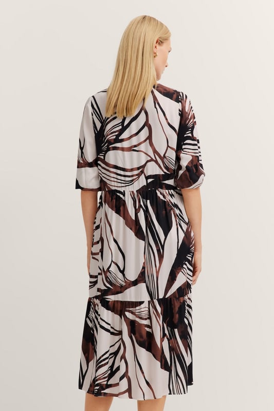 Das bugatti Sommerkleid aus 100  Prozent Viskose vereint zeitlose Eleganz mit modernen Details. Die fließenden Volants und die Teilungsnähte sorgen für eine feminine Silhouette, während praktische Seitennahttaschen und kürzeren Ärmel mit 1-Knopf-Manschette für maximalen Tragekomfort sorgen. Perfekt für stilvolle Auftritte an warmen Tagen!
