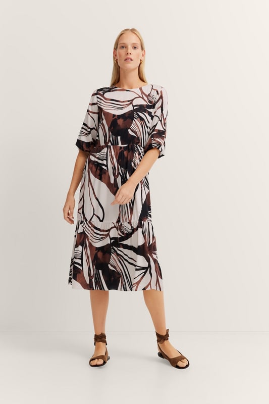 Das bugatti Sommerkleid aus 100  Prozent Viskose vereint zeitlose Eleganz mit modernen Details. Die fließenden Volants und die Teilungsnähte sorgen für eine feminine Silhouette, während praktische Seitennahttaschen und kürzeren Ärmel mit 1-Knopf-Manschette für maximalen Tragekomfort sorgen. Perfekt für stilvolle Auftritte an warmen Tagen!