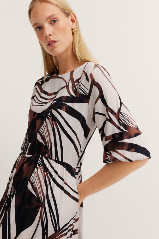 Das bugatti Sommerkleid aus 100  Prozent Viskose vereint zeitlose Eleganz mit modernen Details. Die fließenden Volants und die Teilungsnähte sorgen für eine feminine Silhouette, während praktische Seitennahttaschen und kürzeren Ärmel mit 1-Knopf-Manschette für maximalen Tragekomfort sorgen. Perfekt für stilvolle Auftritte an warmen Tagen!