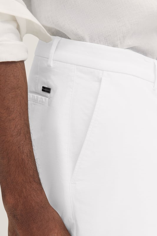 Die bugatti Chino mit ´Tapered Fit`Passform kombiniert einen modernen Schnitt mit flexiblem Komfort dank Elastananteil. Französische Taschen und eine elegante Leistentasche sorgen für ein stilvolles Design, während der Metall-Reißverschluss einen hochwertigen Akzent setzt. Perfekt für einen smarten, zeitgemäßen Look.