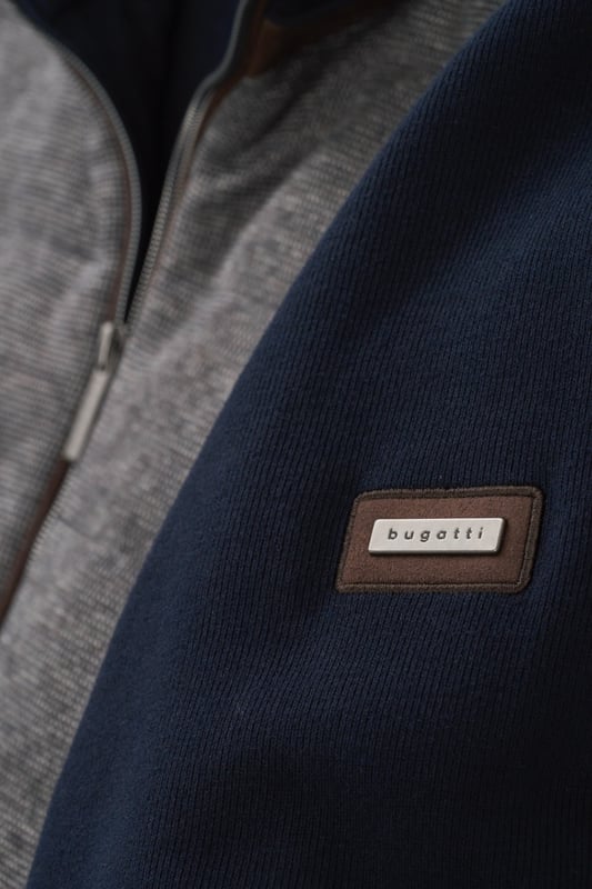 Entdecke die bugatti Sweatjacke für stilvolle Lässigkeit. Gefertigt aus 100 % Baumwolle, vereint die Jacke in Strickoptik Komfort mit Funktionalität. Ausgestattet mit Mikroma-Details, zwei seitlichen Reißverschlusstaschen und einer klassischen Selanik-Textur an den Ärmeln und am Rücken. Der Regular Fit und die Rippenbündchen garantieren eine perfekte Passform. Ideal für den Alltag und darüber hinaus!