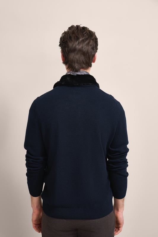 Setze ein modisches Statement mit der bugatti Strickjacke - perfekt für kühle Tage. Diese Jacke aus einem warmen Woll-Mix zeichnet sich durch ihren stilvollen unechten Fellkragen und das attraktive Zopf- und Rautenmuster auf der Vorderseite aus. Ausgestattet mit einem praktischen Reißverschluss und einem komfortablen Umlegekragen, bietet sie eine bequeme Regular-Fit-Passform. Die Rippenbündchen sorgen für einen perfekten Sitz.