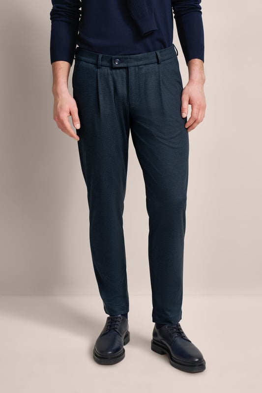 Verleihe deiner Garderobe einen modernen Touch mit der bugatti Bundfaltenhose! Diese Hose mit Elasthananteil sorgt für Komfort und Bewegungsfreiheit. Tapered Fit garantiert eine keilförmige Passform, die durch praktische Gürtelschlaufen und Taschen ergänzt wird. Ein zeitloses Must-have für jeden modischen Mann!
