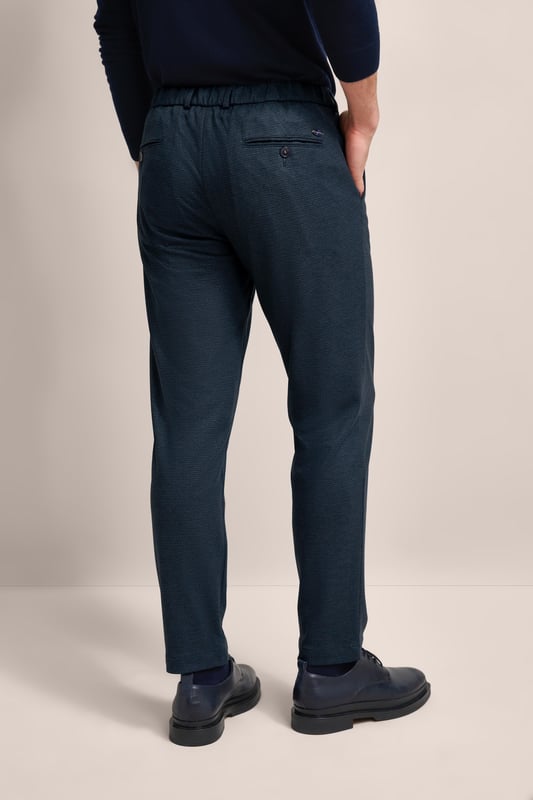 Verleihe deiner Garderobe einen modernen Touch mit der bugatti Bundfaltenhose! Diese Hose mit Elasthananteil sorgt für Komfort und Bewegungsfreiheit. Tapered Fit garantiert eine keilförmige Passform, die durch praktische Gürtelschlaufen und Taschen ergänzt wird. Ein zeitloses Must-have für jeden modischen Mann!