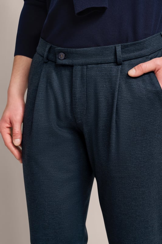 Verleihe deiner Garderobe einen modernen Touch mit der bugatti Bundfaltenhose! Diese Hose mit Elasthananteil sorgt für Komfort und Bewegungsfreiheit. Tapered Fit garantiert eine keilförmige Passform, die durch praktische Gürtelschlaufen und Taschen ergänzt wird. Ein zeitloses Must-have für jeden modischen Mann!