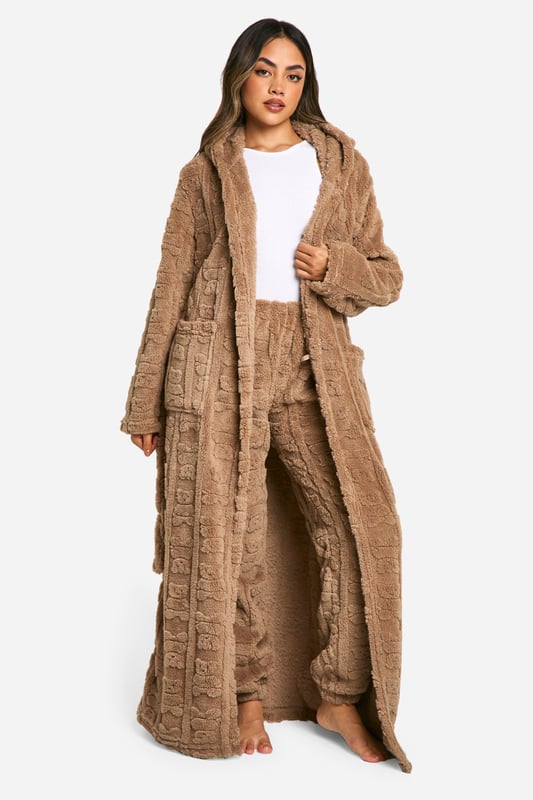 Bear Embossed Fleece Maxi Dressing Gown Luxuriously soft fleece fabric with embossed bear print
Full-length design for maximum coverage and warmth
Cosy hood for added comfort
Practical side pockets for convenience
Adjustable belt to cinch in the waist
Wrap yourself in ultimate comfort with this charming embossed bear print dressing gown. Perfect for those lazy mornings or cosy nights in, this full-length robe offers both style and functionality. The soft fleece fabric envelops you in warmth, while the hood provides an extra layer of snugness. Side pockets offer practicality for keeping your hands warm or storing small essentials. The adjustable belt allows you to customise the fit to your liking, creating a flattering silhouette. Whether you're enjoying a cup of tea on the sofa or preparing for a relaxing night's sleep, this dressing gown is your go-to for luxurious loungewear. Pair with your favourite pyjamas or nightdress for a complete bedtime ensemble that's both fashionable and comfortable.