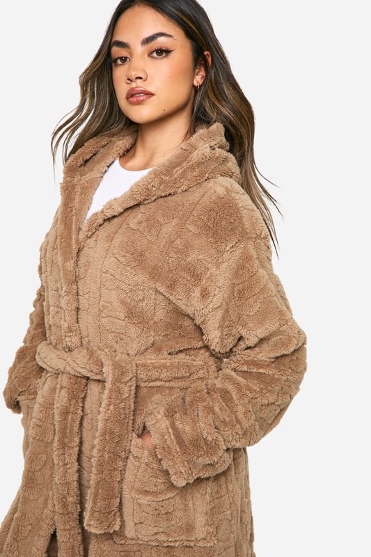 Bear Embossed Fleece Maxi Dressing Gown Luxuriously soft fleece fabric with embossed bear print
Full-length design for maximum coverage and warmth
Cosy hood for added comfort
Practical side pockets for convenience
Adjustable belt to cinch in the waist
Wrap yourself in ultimate comfort with this charming embossed bear print dressing gown. Perfect for those lazy mornings or cosy nights in, this full-length robe offers both style and functionality. The soft fleece fabric envelops you in warmth, while the hood provides an extra layer of snugness. Side pockets offer practicality for keeping your hands warm or storing small essentials. The adjustable belt allows you to customise the fit to your liking, creating a flattering silhouette. Whether you're enjoying a cup of tea on the sofa or preparing for a relaxing night's sleep, this dressing gown is your go-to for luxurious loungewear. Pair with your favourite pyjamas or nightdress for a complete bedtime ensemble that's both fashionable and comfortable.