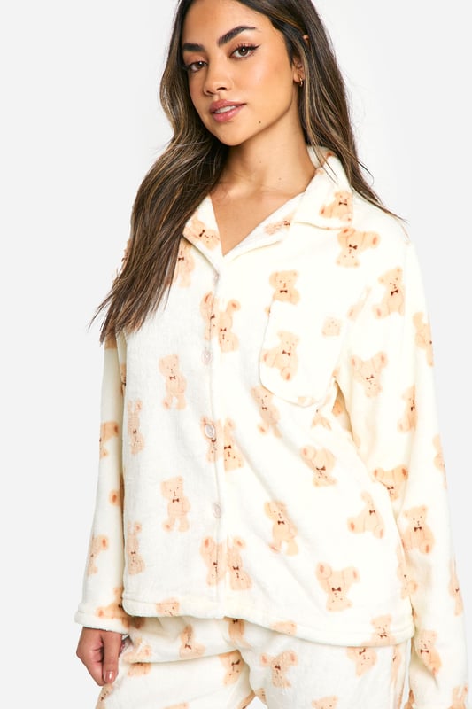 Loungewear Bear Print Fleece Button Front Shirt & Trousers Pyjama Set Adorable bear print fleece pyjama set
Cosy button-up top with notched collar
Relaxed fit trousers with elasticated waistband
Long sleeves for extra warmth
Soft and comfortable fleece fabric
Embrace ultimate comfort with this charming bear fleece pyjama set from Boohoo. Perfect for those chilly nights in, this set combines style and cosiness effortlessly. The button-up top features a classic notched collar and long sleeves, ideal for snuggling up on the sofa. Pair with fluffy slippers and your favourite hot beverage for the ultimate night in. Whether you're having a lazy Sunday morning or a girls' sleepover, this pyjama set is versatile enough for all your loungewear needs. The relaxed fit trousers with an elasticated waistband ensure unrestricted movement, making them perfect for lounging or sleeping. This set is a must-have addition to your loungewear collection, offering both comfort and a touch of whimsy to your relaxation time.