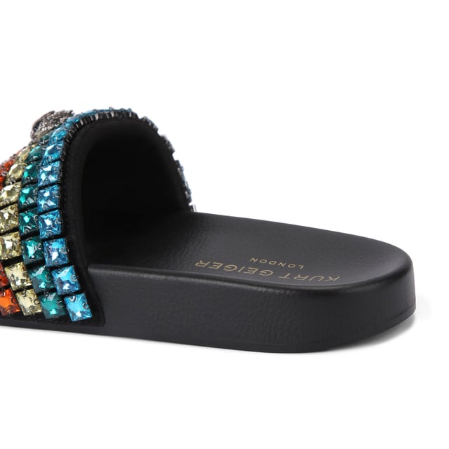 This Carvela Meena Eagle sandal slips onto the foot with a black moulded footbed. The toe strap is designed in the rainbow Kensington weave with Kurt Geiger London branding on a crystal coated canvas. There is an antiqued silver eagle head sat on top.