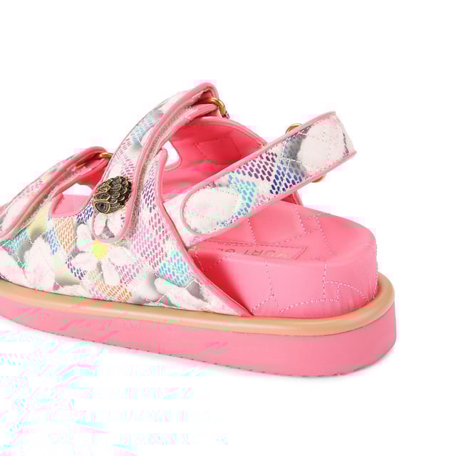 The Kurt Geiger Orson sandal features a canvas fabric upper with watercolour style floral print. The straps are velcro with an antiqued brass eagle head emblem sat on top.