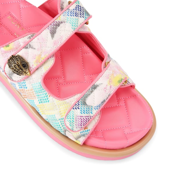 The Kurt Geiger Orson sandal features a canvas fabric upper with watercolour style floral print. The straps are velcro with an antiqued brass eagle head emblem sat on top.