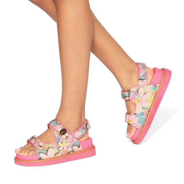 The Kurt Geiger Orson sandal features a canvas fabric upper with watercolour style floral print. The straps are velcro with an antiqued brass eagle head emblem sat on top.