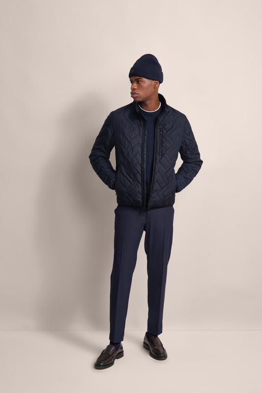 Ervaar het comfort en de stijl van de bugatti blouson in een moderne gewatteerde look. Deze lichtgewicht nylon blouson is ideaal voor op reis en biedt optimaal comfort en warmte met zijn opstaande kraag, gebreide manchetten aan de mouwen en romp en gevoerde voorkant - zonder gebruik van echt dons. Er is ook een praktische zak met rits op de borst!