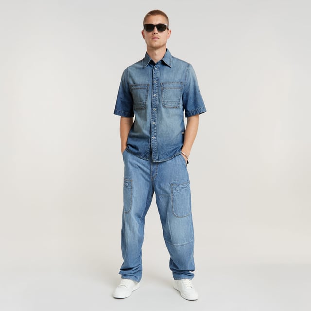 G-Star RAW Travail 3D Relaxed Jeans Integrated belt with buckle. Inset pockets- coin pocket. Reinforced patch pockets front and back- Velcro closure. Button closure. Low waist. Jean Travail 3D is designed in a relaxed, loose fit. Patched pockets are added to the front and back, offering a Velcro closure. Use the integrated belt to style it as you like it. 100% Cotton. 2x1 right hand twill. Lighter weight 8 oz denim. Straight