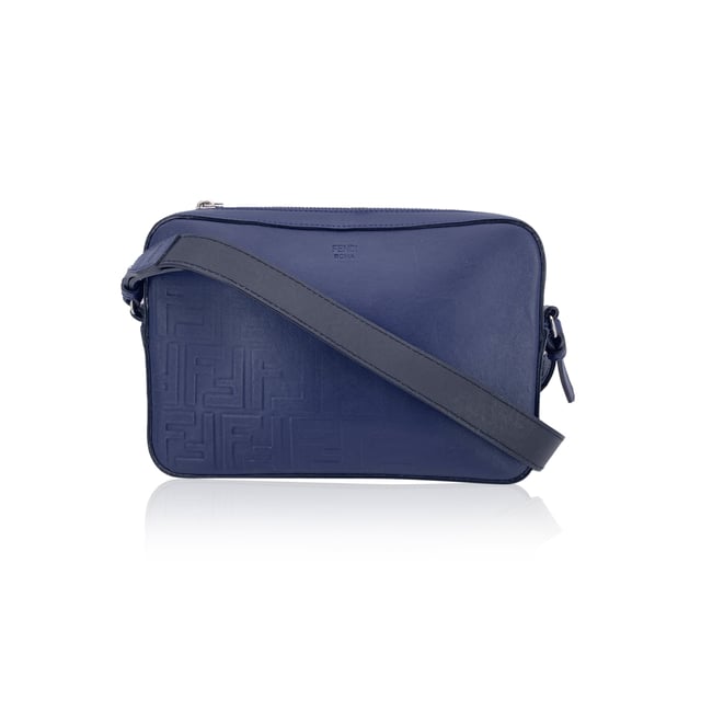 VINTAGE, RRP AS NEW
This beautiful Bag will come with a Certificate of ity provided by Entrupy. The certificate will be provided at no further cost  Step into the timeless elegance of Italian craftsmanship with this Forever Fendi Fade Camera Bag, a true tribute to the house's bold design legacy. Wrapped in rich blue leather, this crossbody tells a story of luxury reimagined for the modern collector.  The front is adorned with the iconic embossed Zucca FF logo, gracefully faded like a memory in motion - a nod to Fendi's heritage that whispers rather than shouts. The silver-tone hardware catches the light just enough to make a statement, while the sleek zip-top closure adds a practical touch to its refined silhouette.  Its single shoulder strap - a striking blend of black and blue leather - adds depth and contrast, letting the bag swing effortlessly between polished city wear and edgy street style. Inside, the black fabric lining reveals thoughtful compartments: a dedicated interior pocket paired with structured card slots for sleek organization.  A discreet 'Fendi - Made in Italy' tag sits proudly inside, with the ity serial number tucked behind - a quiet reassurance of origin for the discerning collector.  A rare find for lovers of second-hand sophistication, this camera bag is more than an accessory - it's a chapter from Fendi's evolving story, waiting to be carried forward. Condition Rating: A - EXCELLENTCondition Details: Gently used. Light scratches on the shoulder strap. Please check the photos carefully and ask if you need to know more details or if you have any doubts.Measurements (cm):Depth: 5.1Height: 15.2Length: 22.9Other Details: Dustbag? YesKeys? NoBox? No Measurments:  width: 51 mm length: 229 mm height: 152 mm strap length: 0 mm handle drop: 0 mm