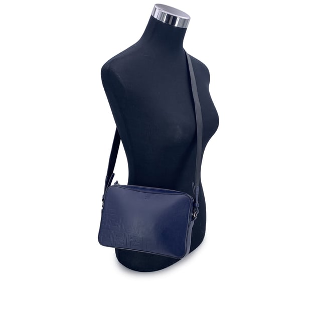 VINTAGE, RRP AS NEW
This beautiful Bag will come with a Certificate of ity provided by Entrupy. The certificate will be provided at no further cost  Step into the timeless elegance of Italian craftsmanship with this Forever Fendi Fade Camera Bag, a true tribute to the house's bold design legacy. Wrapped in rich blue leather, this crossbody tells a story of luxury reimagined for the modern collector.  The front is adorned with the iconic embossed Zucca FF logo, gracefully faded like a memory in motion - a nod to Fendi's heritage that whispers rather than shouts. The silver-tone hardware catches the light just enough to make a statement, while the sleek zip-top closure adds a practical touch to its refined silhouette.  Its single shoulder strap - a striking blend of black and blue leather - adds depth and contrast, letting the bag swing effortlessly between polished city wear and edgy street style. Inside, the black fabric lining reveals thoughtful compartments: a dedicated interior pocket paired with structured card slots for sleek organization.  A discreet 'Fendi - Made in Italy' tag sits proudly inside, with the ity serial number tucked behind - a quiet reassurance of origin for the discerning collector.  A rare find for lovers of second-hand sophistication, this camera bag is more than an accessory - it's a chapter from Fendi's evolving story, waiting to be carried forward. Condition Rating: A - EXCELLENTCondition Details: Gently used. Light scratches on the shoulder strap. Please check the photos carefully and ask if you need to know more details or if you have any doubts.Measurements (cm):Depth: 5.1Height: 15.2Length: 22.9Other Details: Dustbag? YesKeys? NoBox? No Measurments:  width: 51 mm length: 229 mm height: 152 mm strap length: 0 mm handle drop: 0 mm