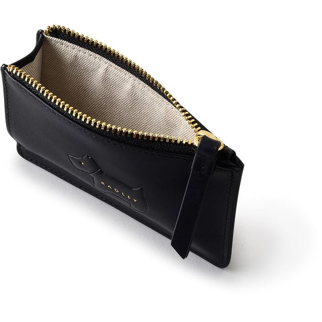 Bolso acolchado negro para mujer de Radley, fabricado con cuero. Presenta: perro scottie acolchado, cierre de cremallera, tres ranuras para tarjetas, tirador de cremallera de cuero y medidas de 12 cm de ancho x 8 cm de alto.