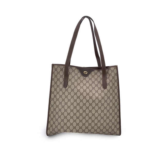 VINTAGE, RRP AS NEW
Step into the understated elegance of the past with this vintage Gucci tote bag, a refined piece from the iconic Gucci Accessory Collection. Crafted in beige monogram canvas, it proudly showcases the unmistakable GG pattern that defined an era of quiet luxury. Trimmed in rich brown genuine leather, this tote exudes both character and classic Italian craftsmanship.  The magnetic button closure opens to a beige fabric-lined interior, complete with a practical side zip pocket for your essentials. Inside, the original 'GUCCI Accessory Collection - Made in Italy' leather tag remains intact, a subtle nod to the brand's heritage and ity.  A timeless piece for those who appreciate vintage luxury with soul, this Gucci tote is more than a bag-it's a story carried on the arm. Condition Rating: B - VERY GOOD CONDITIONCondition Details: Gently used. Minimal wear of use on leather trim. A small white mark on canvas on the bottom. Please check the photos carefully and ask if you need to know more details or if you have any doubts.Measurements (cm):Depth: 11.4Height: 36.8Length: 36.8Other Details: Dustbag? NoKeys? NoBox? No Measurments:  width: 114 mm length: 368 mm height: 368 mm strap length: 0 mm handle drop: 0 mm