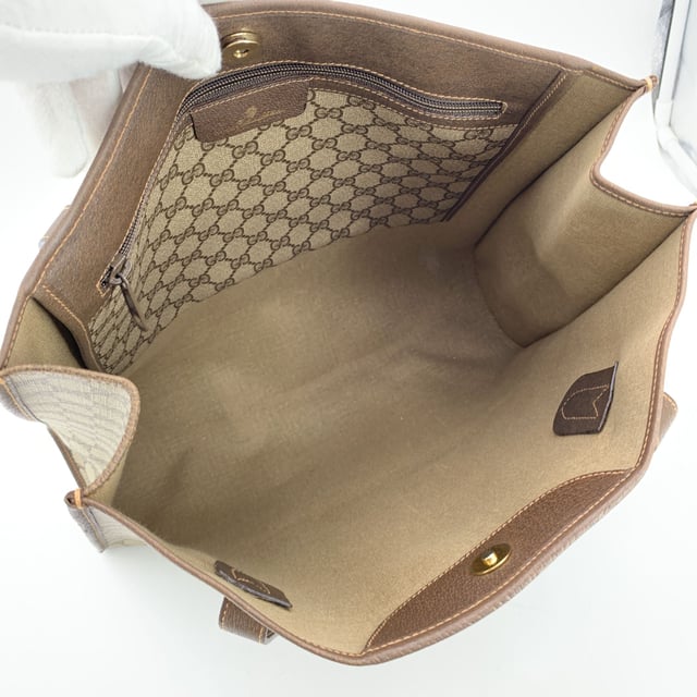 VINTAGE, RRP AS NEW
Step into the understated elegance of the past with this vintage Gucci tote bag, a refined piece from the iconic Gucci Accessory Collection. Crafted in beige monogram canvas, it proudly showcases the unmistakable GG pattern that defined an era of quiet luxury. Trimmed in rich brown genuine leather, this tote exudes both character and classic Italian craftsmanship.  The magnetic button closure opens to a beige fabric-lined interior, complete with a practical side zip pocket for your essentials. Inside, the original 'GUCCI Accessory Collection - Made in Italy' leather tag remains intact, a subtle nod to the brand's heritage and ity.  A timeless piece for those who appreciate vintage luxury with soul, this Gucci tote is more than a bag-it's a story carried on the arm. Condition Rating: B - VERY GOOD CONDITIONCondition Details: Gently used. Minimal wear of use on leather trim. A small white mark on canvas on the bottom. Please check the photos carefully and ask if you need to know more details or if you have any doubts.Measurements (cm):Depth: 11.4Height: 36.8Length: 36.8Other Details: Dustbag? NoKeys? NoBox? No Measurments:  width: 114 mm length: 368 mm height: 368 mm strap length: 0 mm handle drop: 0 mm