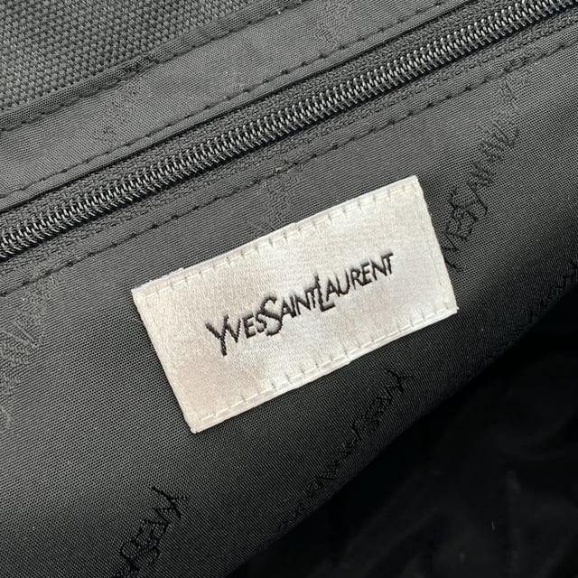 VINTAGE, RRP AS NEW
Understated, refined, and undeniably rare, this Vintage Yves Saint Laurent Pour Homme tote captures the quiet confidence of YSL's menswear line in a form that still feels effortlessly modern. Crafted from durable black nylon canvas and accented with sleek black leather trim, this tote is a functional piece with subtle designer distinction.  At the front, a silver metal Yves Saint Laurent tab adds a discreet touch of luxury, while the magnetic button closure opens to reveal a black nylon canvas lining-clean, simple, and timeless. Inside, a zip pocket offers secure storage, and the original 'Yves Saint Laurent' tag affirms the bag's ity. A true collector's bonus: the 'Yves Saint Laurent Pour Homme' shop hang tag remains thoughtfully attached, hinting at the bag's pristine and possibly unused Condition Rating: A - EXCELLENTCondition Details: Gently used. Yves Saint Laurent hang tag still attached. Please check the photos carefully and ask if you need to know more details or if you have any doubts.Measurements (cm):Depth: 15.2Height: 24.1Length: 35.6Other Details: Dustbag? NoKeys? NoBox? No Measurments:  width: 152 mm length: 356 mm height: 241 mm strap length: 0 mm handle drop: 0 mm