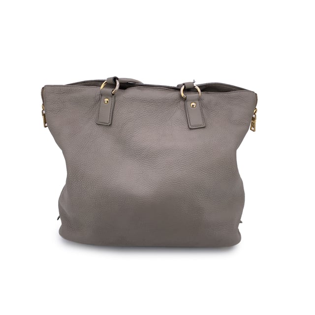 VINTAGE, RRP AS NEW
This beautiful item will come with a Certificate of ity provided by Entrupy. The certificate will be provided at no further cost  Elevate your everyday with this beautiful PRADA tote bag, crafted in luxurious grey taupe textured leather-a timeless neutral that pairs effortlessly with any look. Showcasing PRADA's signature blend of elegance and functionality, this tote features structured double top handles and refined silver-tone Prada lettering on the front, adding a touch of quiet sophistication.  The top opens with a button closure to reveal a spacious main compartment, fully lined in PRADA's iconic jacquard fabric. Inside, you'll find one zip pocket and one open pocket to keep your essentials neatly organized. A 'PRADA Milano' tag and a discreet numbered label tucked inside the interior pocket ensure ity.  Finished with four metal bottom feet for added protection and polish, this tote is as practical as it is chic-perfect for the modern woman who values understated luxury. Condition Rating: B - VERY GOOD CONDITIONCondition Details: Some wear of use on the upper border (please see photos). Some wear of use on the hardware. Please check the photos carefully and ask if you need to know more details or if you have any doubts.Measurements (cm):Depth: 15.2Height: 34.3Length: 36.8Other Details: Dustbag? NoKeys? NoBox? No Measurments:  width: 152 mm length: 368 mm height: 343 mm strap length: 0 mm handle drop: 0 mm