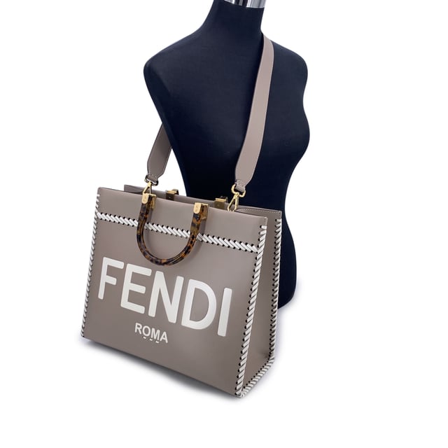 VINTAGE, RRP AS NEW
This beautiful item will come with a Certificate of ity provided by Entrupy. The certificate will be provided at no further cost  Sophisticated and striking, the FENDI Sunshine Medium Shopper Tote in Tortora taupe leather is a modern classic with a nod to vintage elegance. This iconic model blends clean Italian lines with statement-making Condition Rating: A - EXCELLENTCondition Details: Gently used. Minimal creases on leather along the borders. Please check the photos carefully and ask if you need to know more details or if you have any doubts.Measurements (cm):Depth: 15.2Height: 26.7Length: 35.6Other Details: Dustbag? NoKeys? NoBox? No Measurments:  width: 152 mm length: 356 mm height: 267 mm strap length: 0 mm handle drop: 0 mm