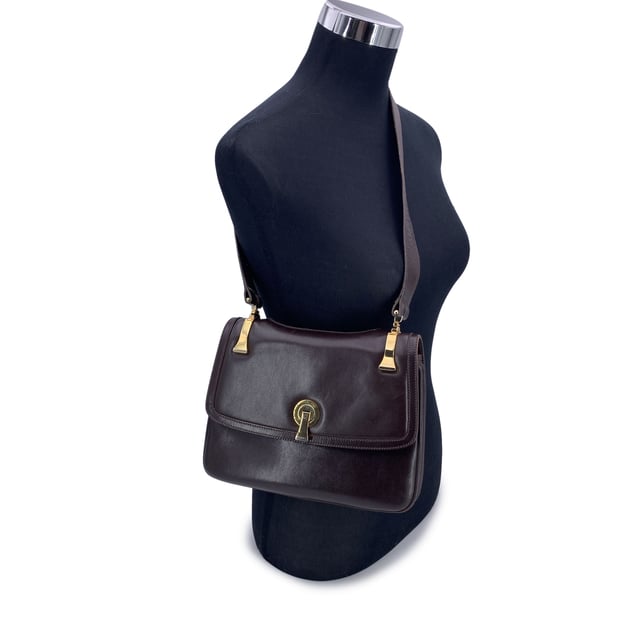 VINTAGE, RRP AS NEW
A classic from Gucci's rich leather-making legacy, this vintage brown leather shoulder bag is a quiet nod to Italian elegance. Crafted in smooth, warm-toned leather that has only grown more beautiful with time, it carries the character of decades past - where form met function with impeccable style.  The front flap features a sleek clasp closure, opening to a thoughtfully designed interior lined in matching brown leather. Inside, you'll find two main compartments, alongside a side zip pocket and a side open pocket - ideal for keeping essentials organized while on the move.  The adjustable leather shoulder strap allows for comfortable wear, whether slung casually or carried with intention. Stamped inside with 'Made in Italy by Gucci', this piece bears the unmistakable signature of quality and heritage.  Understated, refined, and deeply rooted in Gucci tradition, this shoulder bag is a timeless companion for lovers of vintage with an eye for craftsmanship. Condition Rating: B - VERY GOOD CONDITIONCondition Details: Some normal wear of use on leather (light scratches). Some light loss of gilding on the hardware. Some scratches on the internal lining. Please check the photos carefully and ask if you need to know more details or if you have any doubtsMeasurements (cm):Depth: 3.8Height: 19.1Length: 25.4Other Details: Dustbag? NoKeys? NoBox? No Measurments:  width: 38 mm length: 254 mm height: 191 mm strap length: 0 mm handle drop: 0 mm
