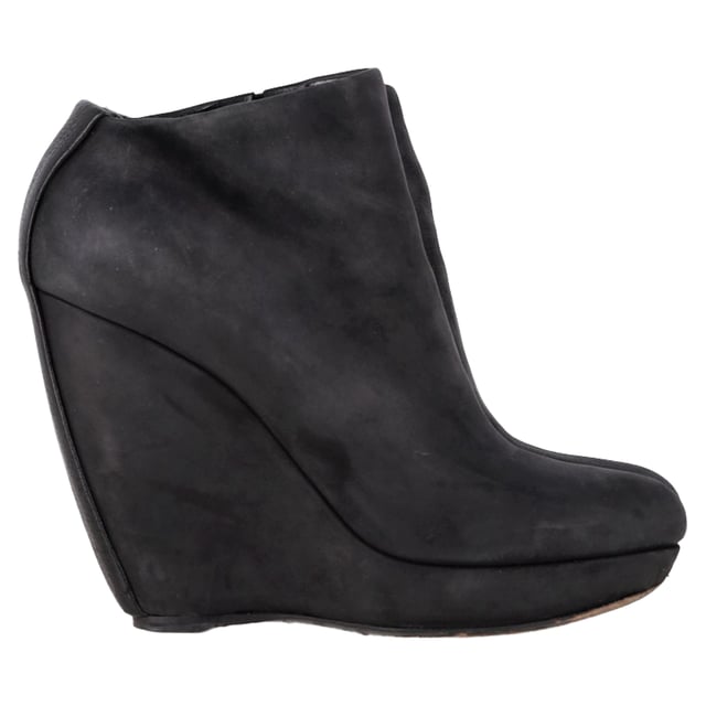 VINTAGE, RRP AS NEW
 Command attention with the Balenciaga Wedge Ankle Boots in black suede, merging sleek sophistication with architectural edge. The sculptural wedge heel and soft suede finish create a bold yet refined silhouette perfect for day-to-night wear. **Style Tip:** Style them with a midi skirt and structured blazer for a chic, contemporary twist on classic tailoring.

Balenciaga Wedge Ankle Boots in Black Suede

Condition: Good
Signs of wear: Moderate signs of wear or markings, moderate scuffing insoles., Used but well maintained. Moderate creasing and marks at surface, wear at soles or replaced soles.
Packaging: None
Color: Black
Material: Suede | suede
Size: IT | 38.5
Measurements: Heel height: 125; Insole length: 255
SKU: BAPUGBSH508323W