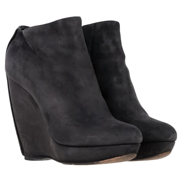VINTAGE, RRP AS NEW
 Command attention with the Balenciaga Wedge Ankle Boots in black suede, merging sleek sophistication with architectural edge. The sculptural wedge heel and soft suede finish create a bold yet refined silhouette perfect for day-to-night wear. **Style Tip:** Style them with a midi skirt and structured blazer for a chic, contemporary twist on classic tailoring.

Balenciaga Wedge Ankle Boots in Black Suede

Condition: Good
Signs of wear: Moderate signs of wear or markings, moderate scuffing insoles., Used but well maintained. Moderate creasing and marks at surface, wear at soles or replaced soles.
Packaging: None
Color: Black
Material: Suede | suede
Size: IT | 38.5
Measurements: Heel height: 125; Insole length: 255
SKU: BAPUGBSH508323W