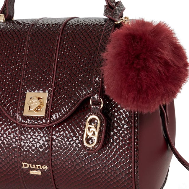 Dassios is the chic day bag that balances polish with practicality. Crafted with a contrasting textured side panel for a subtle style twist, it features a sleek turn-lock closure and a structured top handle for timeless appeal. Inside, the monogrammed lining reveals two spacious compartments ' one zipped for added security ' keeping your essentials neatly organised. Carry it by hand for a sophisticated look, or attach the optional long strap for a hands-free cross-body style. Finished with a removable logo and plush faux-fur pom-pom charm, Dassios is your go-to for effortless everyday elegance