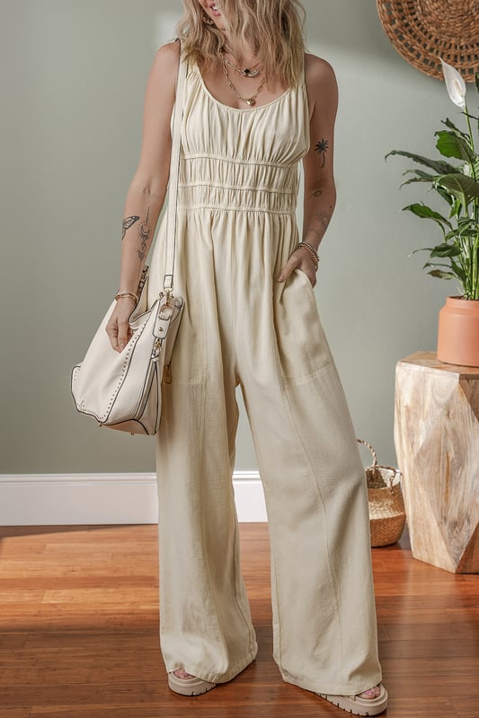 Beige geraffte High-Waist ärmellose weite Jumpsuit  
Flatternde geraffte Details fügen Textur und Dimension hinzu  
Einfarbiges Design bietet endlose Styling-Möglichkeiten  
Das High-Waist-Design definiert die Taille und verlängert die Silhouette  
Ärmellose Silhouette sorgt für ein modernes und luftiges Gefühl  
Material: 100 % Baumwolle