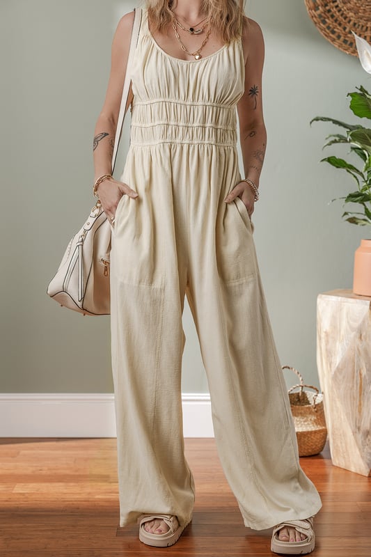 Beige geraffte High-Waist ärmellose weite Jumpsuit  
Flatternde geraffte Details fügen Textur und Dimension hinzu  
Einfarbiges Design bietet endlose Styling-Möglichkeiten  
Das High-Waist-Design definiert die Taille und verlängert die Silhouette  
Ärmellose Silhouette sorgt für ein modernes und luftiges Gefühl  
Material: 100 % Baumwolle
