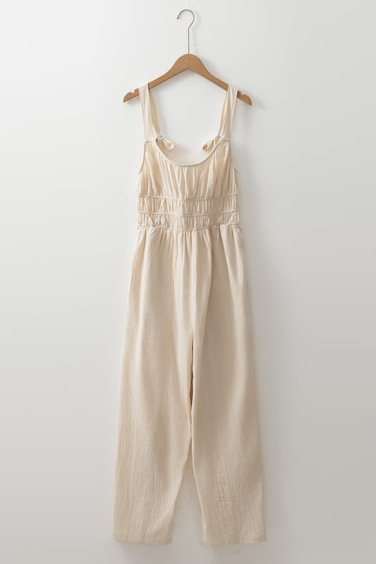 Beige geraffte High-Waist ärmellose weite Jumpsuit  
Flatternde geraffte Details fügen Textur und Dimension hinzu  
Einfarbiges Design bietet endlose Styling-Möglichkeiten  
Das High-Waist-Design definiert die Taille und verlängert die Silhouette  
Ärmellose Silhouette sorgt für ein modernes und luftiges Gefühl  
Material: 100 % Baumwolle