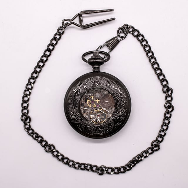 Elegante, mechanische Skelett-Taschenuhr mit Half-Hunter-Gehäuse und Sichtfenster. Inklusive passender Kette und Samtbeutel. Ideal für Sammler, Vintage-Liebhaber oder als unverwechselbares Geschenk. Wichtige Eigenschaften Mechanisches Skelett-Uhrwerk: Präsentiert das komplizierte Innenleben durch sein Skelett-Zifferblatt und bietet ein klassisches mechanisches Aufziehwerk für alle, die traditionelle Handwerkskunst schätzen. Half-Hunter-Gehäusedesign: Verfügt über ein Half-Hunter-Gehäuse mit Sichtfenster, sodass Sie die Uhrzeit ablesen können, ohne die Uhr ganz öffnen zu müssen, während das Zifferblatt vor Kratzern und Staub geschützt ist. Vintage-inspirierte Ästhetik: Mit Details im Antik-Stil verleiht diese Taschenuhr einen Hauch von altmodischem Charme und macht sie zu einem unverwechselbaren Accessoire für formelle Kleidung oder Sammlungszwecke. Passende Kette enthalten: Wird komplett mit einer passenden Kette zur sicheren Befestigung an einer Weste, Gürtelschlaufe oder Tasche geliefert und bietet sowohl Stil als auch Funktionalität. Material: Die Legierungskonstruktion gewährleistet Haltbarkeit und eine zeitlose Ästhetik.