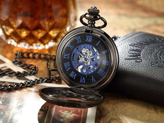 Elegante, mechanische Skelett-Taschenuhr mit Half-Hunter-Gehäuse und Sichtfenster. Inklusive passender Kette und Samtbeutel. Ideal für Sammler, Vintage-Liebhaber oder als unverwechselbares Geschenk. Wichtige Eigenschaften Mechanisches Skelett-Uhrwerk: Präsentiert das komplizierte Innenleben durch sein Skelett-Zifferblatt und bietet ein klassisches mechanisches Aufziehwerk für alle, die traditionelle Handwerkskunst schätzen. Half-Hunter-Gehäusedesign: Verfügt über ein Half-Hunter-Gehäuse mit Sichtfenster, sodass Sie die Uhrzeit ablesen können, ohne die Uhr ganz öffnen zu müssen, während das Zifferblatt vor Kratzern und Staub geschützt ist. Vintage-inspirierte Ästhetik: Mit Details im Antik-Stil verleiht diese Taschenuhr einen Hauch von altmodischem Charme und macht sie zu einem unverwechselbaren Accessoire für formelle Kleidung oder Sammlungszwecke. Passende Kette enthalten: Wird komplett mit einer passenden Kette zur sicheren Befestigung an einer Weste, Gürtelschlaufe oder Tasche geliefert und bietet sowohl Stil als auch Funktionalität. Material: Die Legierungskonstruktion gewährleistet Haltbarkeit und eine zeitlose Ästhetik.