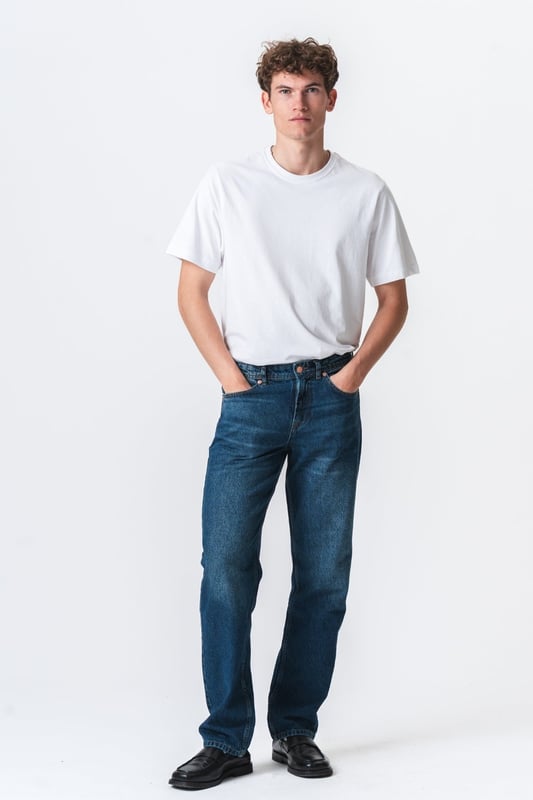 Descubre tu nueva prenda favorita con los jeans Relaxed Fit de TeeShoppen en un azul oscuro profundo y versátil. Imagina la libertad de unos jeans que se sienten tan bien como se ven, de la mañana a la noche.

Experimenta la máxima comodidad y un estilo atemporal.

Nuestros jeans Relaxed Fit están diseñados pensando en tu comodidad. Hechos con 100% algodón puro, estos jeans ofrecen una suavidad excepcional y transpirabilidad que te mantiene fresco todo el día. El azul oscuro es un clásico que nunca pasa de moda y se puede combinar fácilmente para ocasiones formales o informales, según la ocasión.

Hechos para tu día a día: de lo casual a lo elegante.

Ya sea para el trabajo, el ocio o una salida nocturna, estos jeans Relaxed Fit de TeeShoppen son tu aliado de confianza. Su versátil color azul oscuro los hace fáciles de combinar con el resto de tu armario. Combínalos con una camiseta sencilla y zapatillas para un look casual y moderno para todos los días. ¿Necesitas algo un poco más formal? Combínalos con una camisa elegante y unos zapatos de cuero y estarás listo para salir en un instante.

Estos jeans están diseñados para el hombre que quiere verse bien sin necesidad de hacerlo. Su corte holgado te garantiza comodidad sin importar lo que te traiga el día, mientras que el algodón puro deja que tu piel respire. Son el tipo de jeans que usarás una y otra vez porque simplemente funcionan.