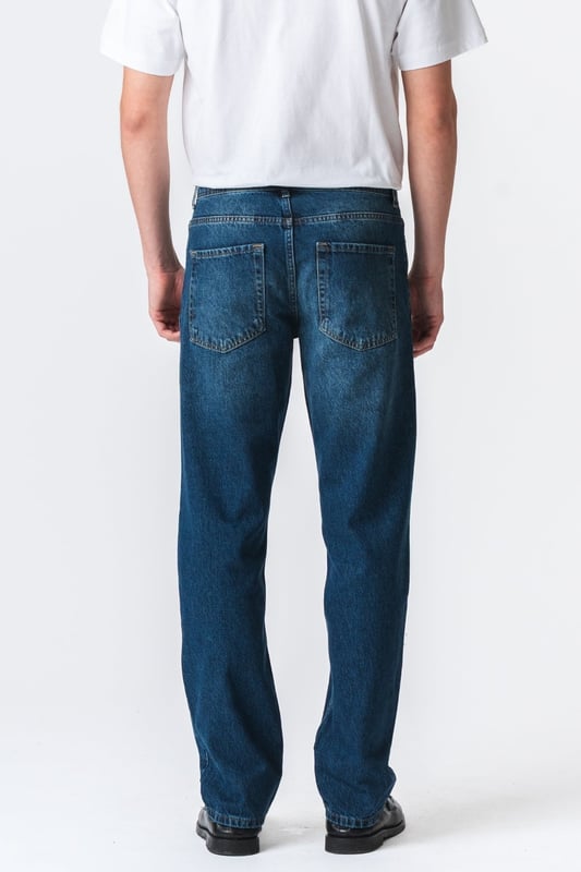 Descubre tu nueva prenda favorita con los jeans Relaxed Fit de TeeShoppen en un azul oscuro profundo y versátil. Imagina la libertad de unos jeans que se sienten tan bien como se ven, de la mañana a la noche.

Experimenta la máxima comodidad y un estilo atemporal.

Nuestros jeans Relaxed Fit están diseñados pensando en tu comodidad. Hechos con 100% algodón puro, estos jeans ofrecen una suavidad excepcional y transpirabilidad que te mantiene fresco todo el día. El azul oscuro es un clásico que nunca pasa de moda y se puede combinar fácilmente para ocasiones formales o informales, según la ocasión.

Hechos para tu día a día: de lo casual a lo elegante.

Ya sea para el trabajo, el ocio o una salida nocturna, estos jeans Relaxed Fit de TeeShoppen son tu aliado de confianza. Su versátil color azul oscuro los hace fáciles de combinar con el resto de tu armario. Combínalos con una camiseta sencilla y zapatillas para un look casual y moderno para todos los días. ¿Necesitas algo un poco más formal? Combínalos con una camisa elegante y unos zapatos de cuero y estarás listo para salir en un instante.

Estos jeans están diseñados para el hombre que quiere verse bien sin necesidad de hacerlo. Su corte holgado te garantiza comodidad sin importar lo que te traiga el día, mientras que el algodón puro deja que tu piel respire. Son el tipo de jeans que usarás una y otra vez porque simplemente funcionan.