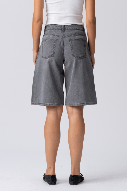 Descubre tu nueva obsesión de verano: Pantalones cortos vaqueros grises

Adéntrate en la frescura sin esfuerzo y la comodidad inigualable de los pantalones cortos vaqueros grises de TeeShoppen, diseñados para la mujer moderna que valora tanto el estilo como la esencia. No son unos shorts vaqueros cualquiera; son tu próxima prenda básica, listas para disfrutar de aventuras soleadas, fines de semana relajados y todo lo demás. Imagina una prenda versátil que combina a la perfección un estilo moderno con la comodidad para el día a día: esa es la promesa de nuestros pantalones cortos vaqueros grises, elaborados meticulosamente.

Experimenta una comodidad inigualable: Confeccionados con 100 % algodón puro

Los pantalones cortos vaqueros grises de TeeShoppen están diseñados pensando en la silueta femenina. Su corte es moderno y atemporal, con un largo favorecedor, práctico y elegante. Cubren para mayor comodidad y realzan las piernas, logrando el equilibrio perfecto para un look veraniego chic. El diseño clásico de los pantalones cortos presenta detalles esenciales como bolsillos funcionales y un cierre seguro, combinando moda y practicidad.
