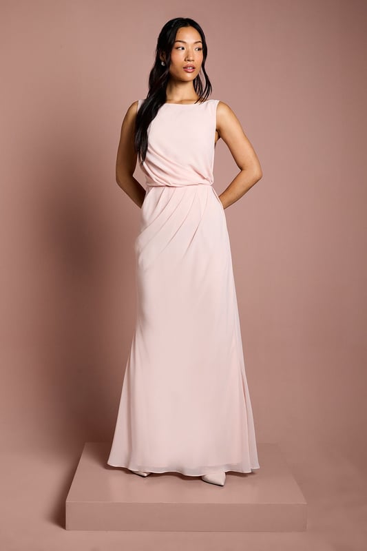 Elegant boat neckline creates a sophisticated silhouette perfect for bridal party ensembles
        Luxurious satin georgette fabric drapes beautifully for a graceful, flowing effect
        Stunning lace back detail adds a romantic touch with delicate scalloped edges
        Floor-sweeping maxi length offers timeless bridal party elegance
        Gathered waist design creates a flattering shape whilst maintaining comfort throughout the celebration
    
    This exquisite Coast bridesmaids dress combines classic elegance with contemporary detailing, making it the perfect choice for your bridal party. The refined boat neckline frames the dcolletage beautifully, whilst the flowing maxi silhouette creates a graceful presence as you move down the aisle. The showstopping feature is undoubtedly the intricate lace back detailing, offering a romantic contrast to the smooth satin georgette fabric. Style with delicate drop earrings and an elegant updo to showcase the beautiful back detail. For a coordinated bridal party look, this dress works wonderfully in matching tones or complementary shades within your wedding colour palette. The gathered waist ensures comfort throughout the ceremony and reception, allowing bridesmaids to move with ease whilst maintaining that picture-perfect silhouette as they support the bride on her special day.