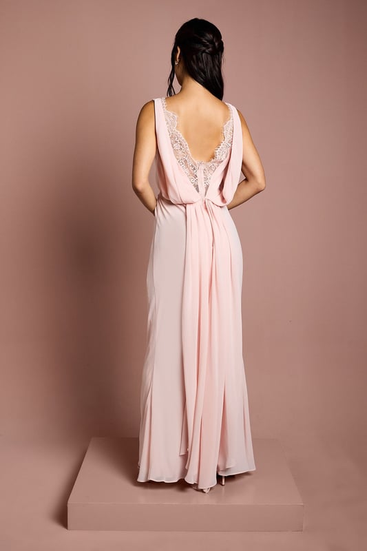 Elegant boat neckline creates a sophisticated silhouette perfect for bridal party ensembles
        Luxurious satin georgette fabric drapes beautifully for a graceful, flowing effect
        Stunning lace back detail adds a romantic touch with delicate scalloped edges
        Floor-sweeping maxi length offers timeless bridal party elegance
        Gathered waist design creates a flattering shape whilst maintaining comfort throughout the celebration
    
    This exquisite Coast bridesmaids dress combines classic elegance with contemporary detailing, making it the perfect choice for your bridal party. The refined boat neckline frames the dcolletage beautifully, whilst the flowing maxi silhouette creates a graceful presence as you move down the aisle. The showstopping feature is undoubtedly the intricate lace back detailing, offering a romantic contrast to the smooth satin georgette fabric. Style with delicate drop earrings and an elegant updo to showcase the beautiful back detail. For a coordinated bridal party look, this dress works wonderfully in matching tones or complementary shades within your wedding colour palette. The gathered waist ensures comfort throughout the ceremony and reception, allowing bridesmaids to move with ease whilst maintaining that picture-perfect silhouette as they support the bride on her special day.