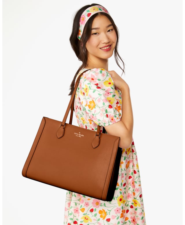 Stay Organized On The Go With Our Madison Laptop Tote. Stylish And Practical, It's Crafted From Durable Saffiano Leather With A Sleek East-West Design. Plus, It Features Multiple Pockets For Essentials Like A Laptop, Wallet And More., Madison Saffiano Leather East West Leather Laptop Tote, Metal Pinmount With Logo, Back Zip And Front Slip Pockets, Middle Zip Compartment,  Length: 17.00 Cm,  Width: 28.50 Cm,  Height: 39.50 Cm